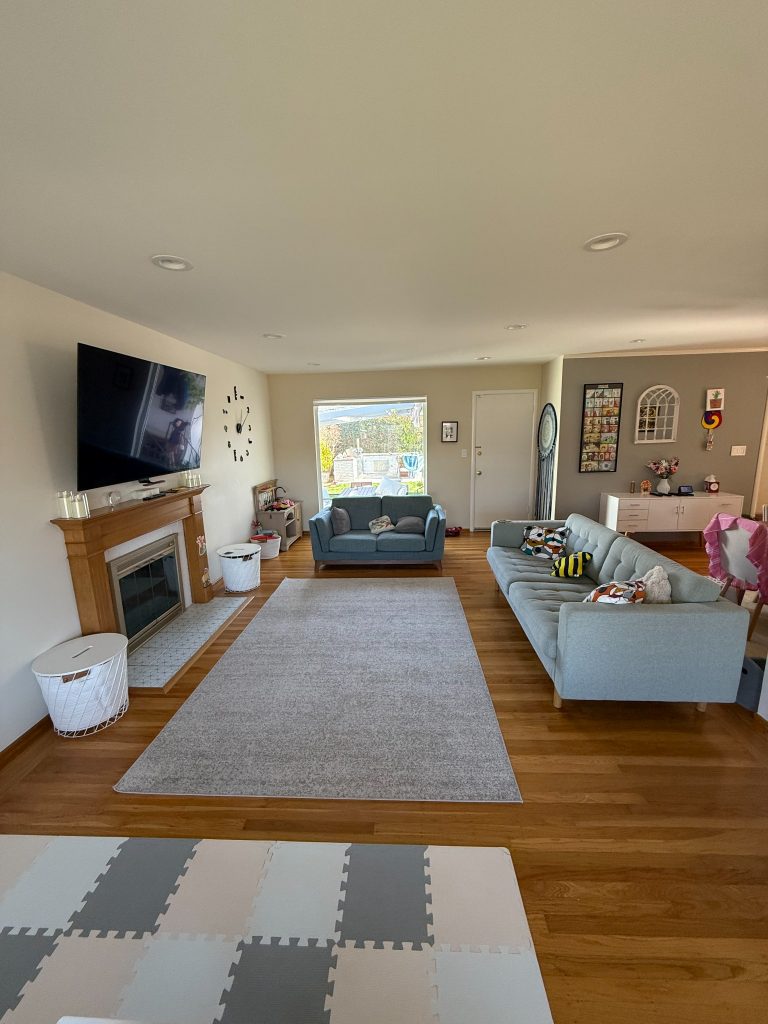Before: side view of living room showing blank wall and small sofa